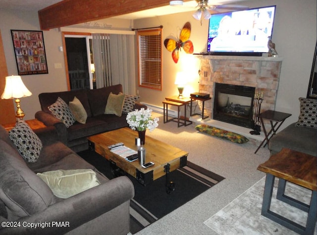 living area with carpet, a baseboard radiator, ceiling fan, a stone fireplace, and beamed ceiling