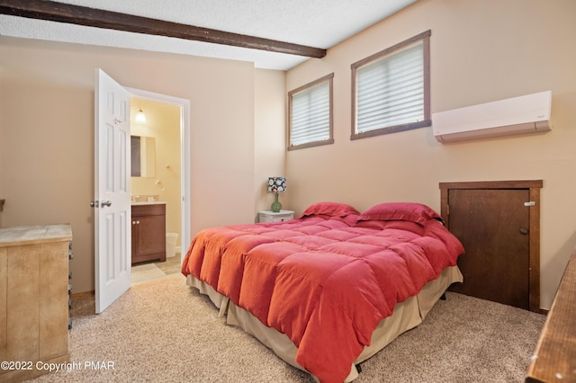 bedroom featuring light carpet, beamed ceiling, ensuite bathroom, a wall mounted air conditioner, and a textured ceiling