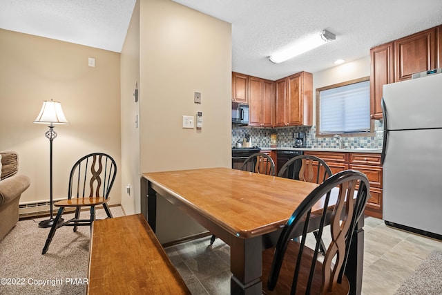 kitchen featuring black appliances, tasteful backsplash, brown cabinets, and a textured ceiling