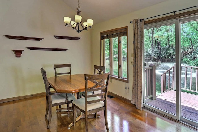 dining space with a chandelier, wood finished floors, and baseboards