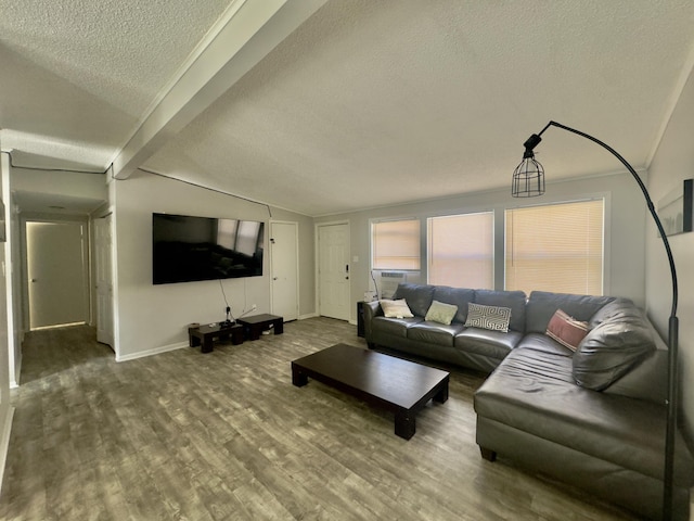 living area featuring a textured ceiling, lofted ceiling with beams, baseboards, and wood finished floors