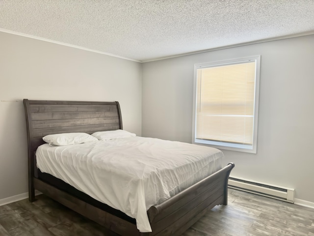 bedroom with a textured ceiling, wood finished floors, and a baseboard radiator