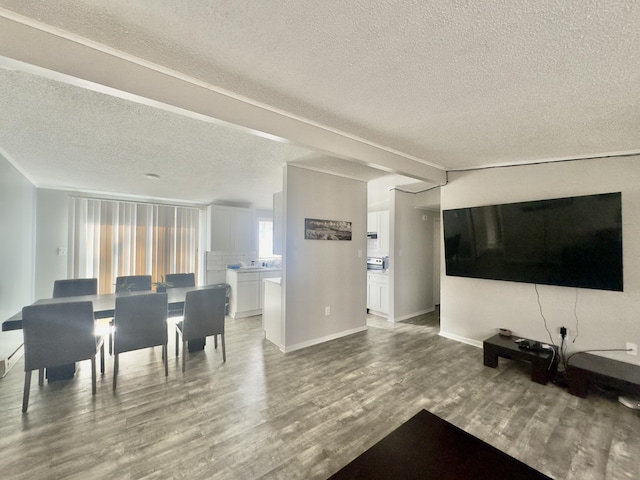 living room featuring wood finished floors, baseboards, and a textured ceiling