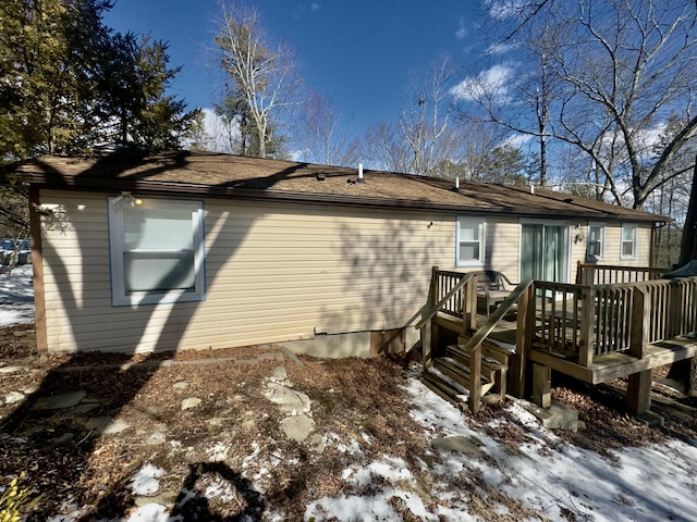 snow covered property with a deck