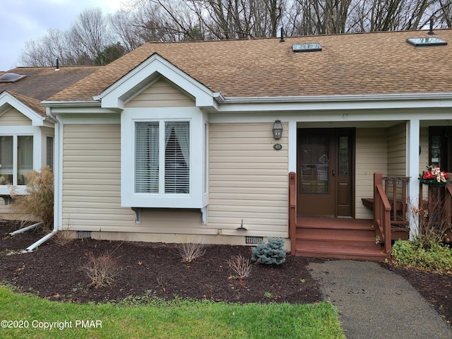 view of front of home featuring crawl space, covered porch, and a shingled roof