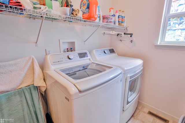 washroom with independent washer and dryer and baseboards