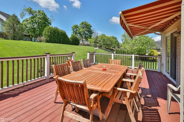 deck featuring outdoor dining area and a lawn