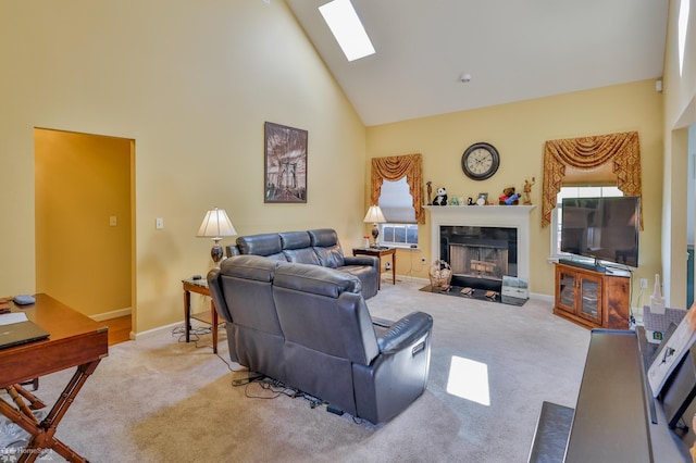 carpeted living room featuring high vaulted ceiling, a fireplace with flush hearth, baseboards, and a skylight