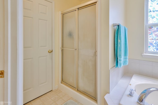 bathroom featuring plenty of natural light, a stall shower, and a bath