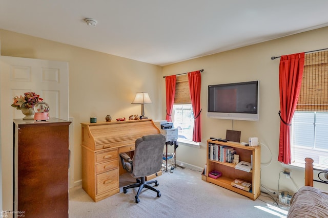 carpeted home office featuring healthy amount of natural light and baseboards