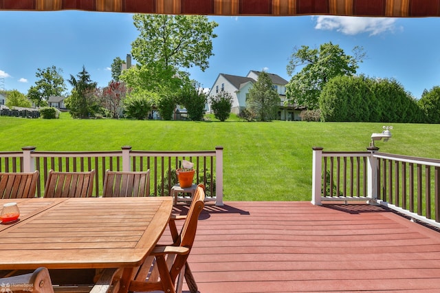 wooden deck with a yard and outdoor dining area
