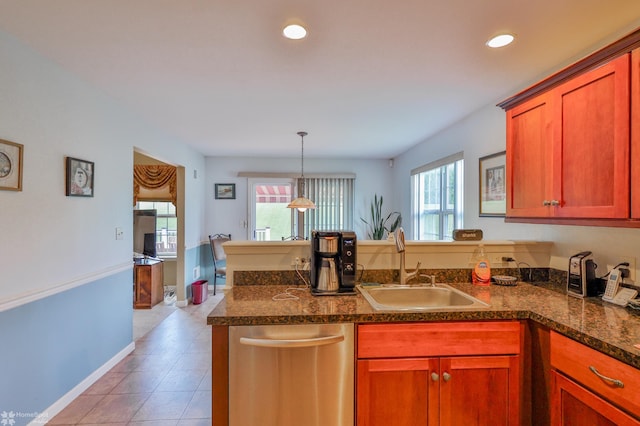 kitchen with a sink, a peninsula, dishwasher, dark countertops, and light tile patterned flooring