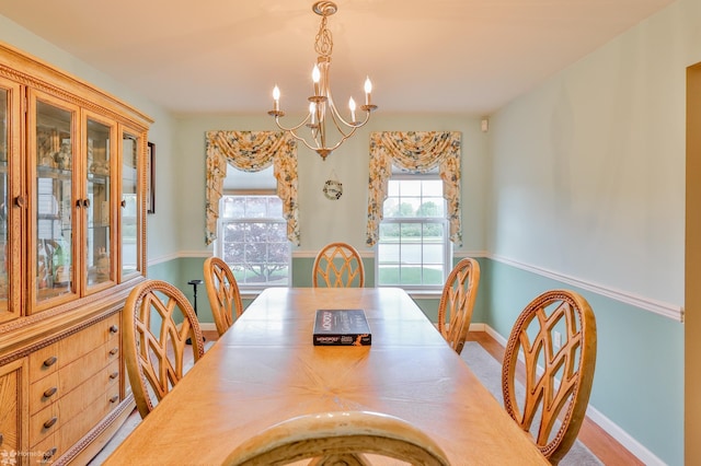 dining room featuring a chandelier and baseboards