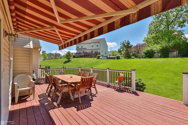 wooden terrace featuring outdoor dining space and a yard