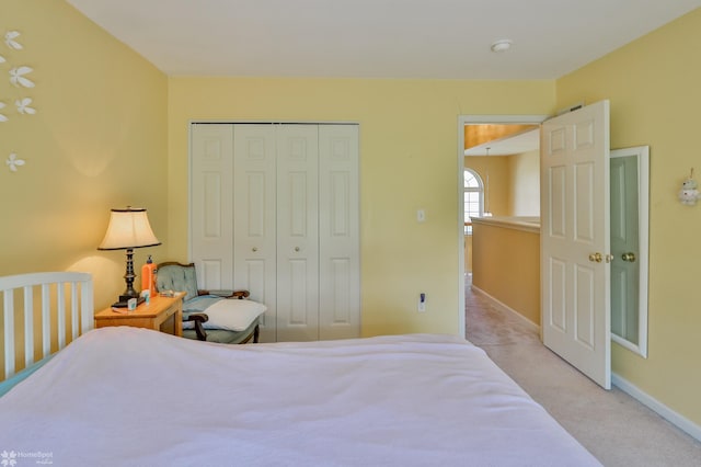 carpeted bedroom with baseboards and a closet
