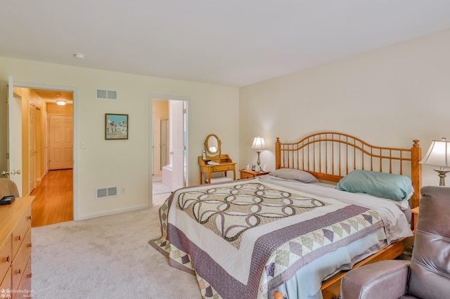 carpeted bedroom featuring baseboards and ensuite bath
