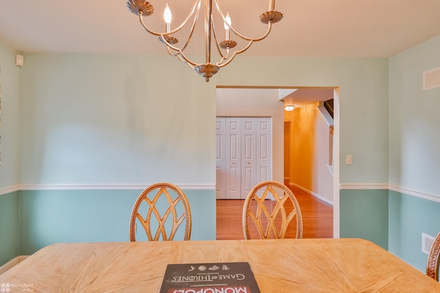 dining area with wood finished floors and a chandelier