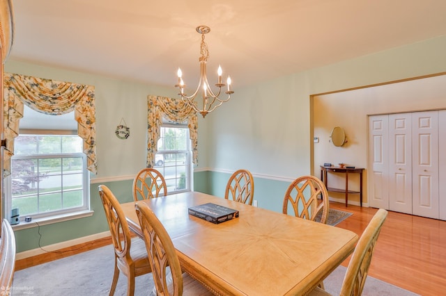dining space with a chandelier, wood finished floors, and baseboards