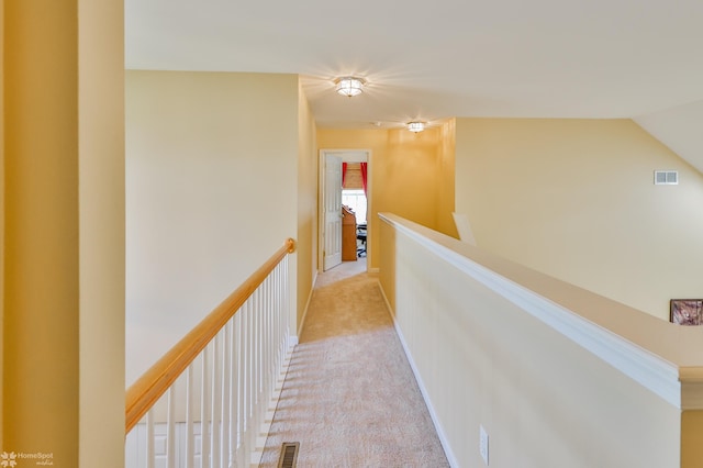 hall with an upstairs landing and carpet