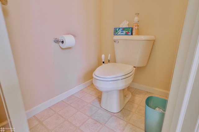 bathroom with toilet and baseboards