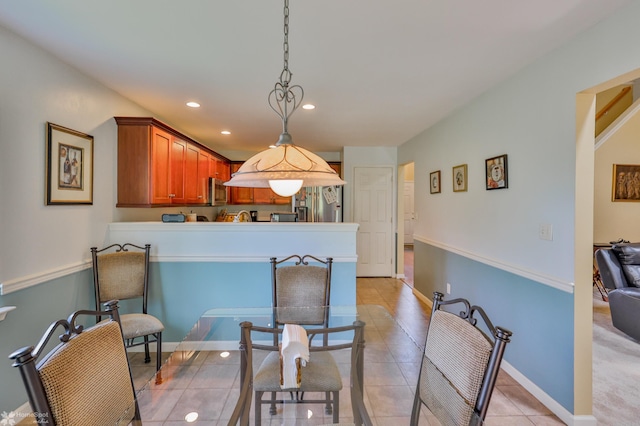 kitchen featuring stainless steel fridge with ice dispenser, light tile patterned flooring, pendant lighting, recessed lighting, and brown cabinets