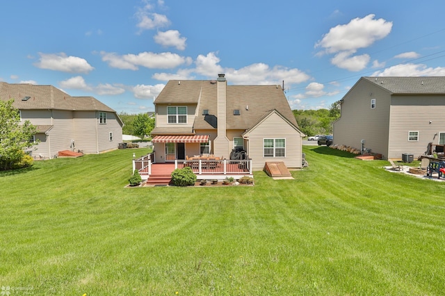 back of house featuring a wooden deck, a yard, and a chimney