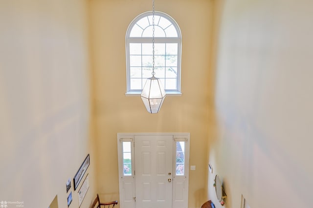 entryway with a towering ceiling and a chandelier