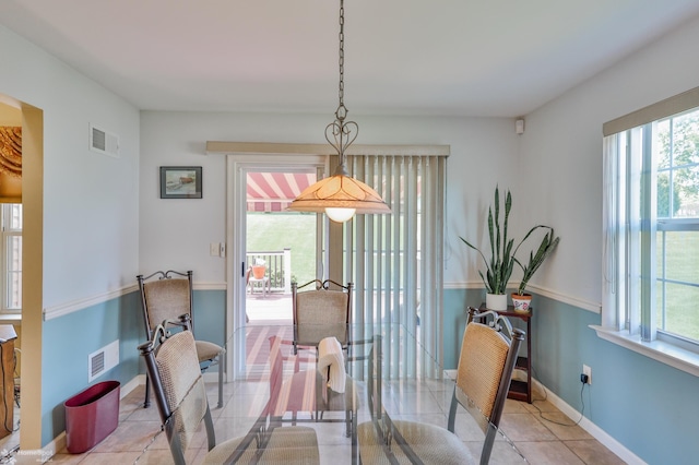 dining space with healthy amount of natural light, light tile patterned floors, and baseboards