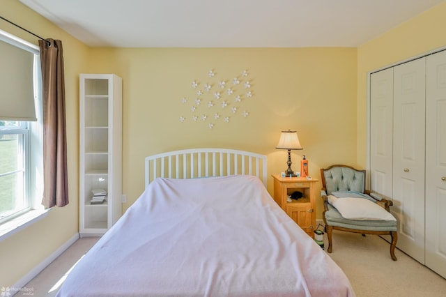 carpeted bedroom featuring a closet and baseboards