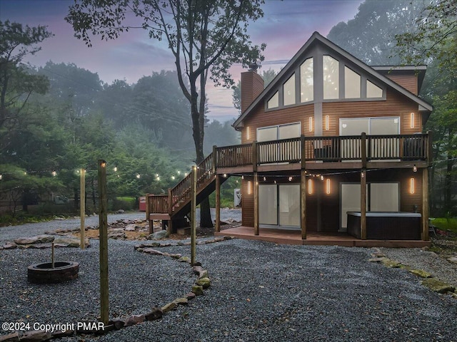 back house at dusk with a patio and a wooden deck