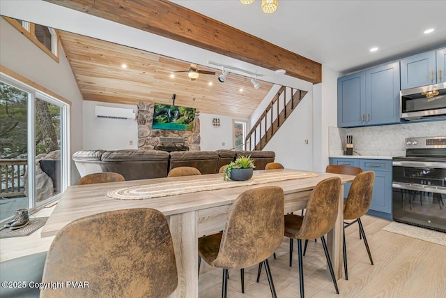 dining space with light wood-type flooring, a wall mounted AC, wood ceiling, a fireplace, and lofted ceiling with beams