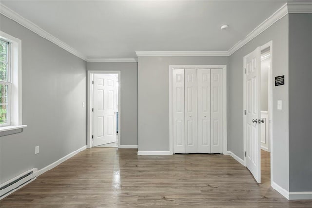 1572 Gardner Rd, Stroudsburg, PA 18360 - unfurnished bedroom featuring baseboard heating, wood finished floors, ornamental molding, and a closet