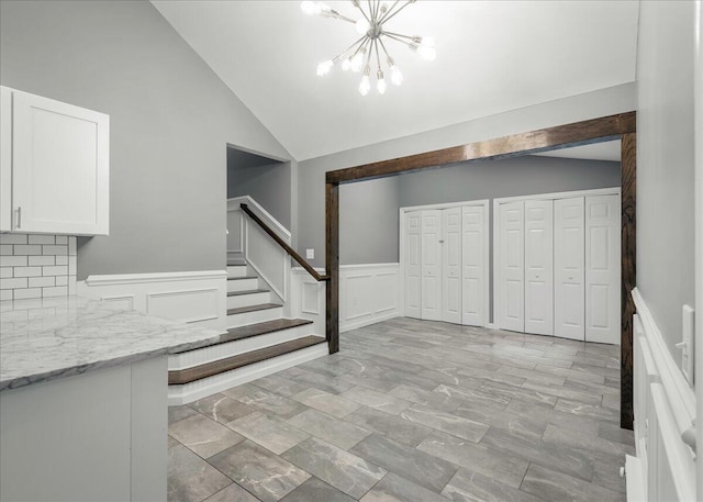 1572 Gardner Rd, Stroudsburg, PA 18360 - entrance foyer featuring stairs, a chandelier, vaulted ceiling, a decorative wall, and wainscoting
