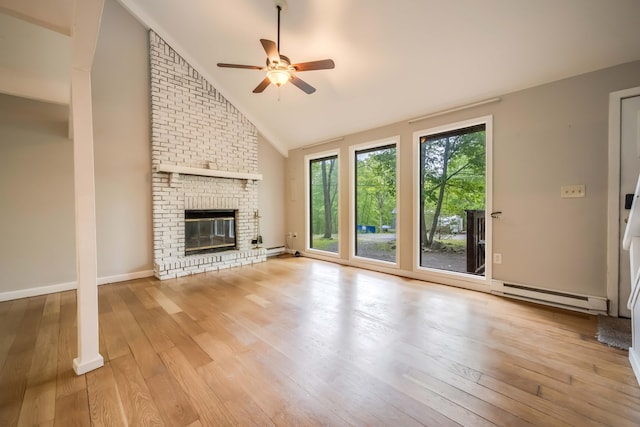 2166 Southport Dr, Bushkill, PA 18324 - unfurnished living room with baseboard heating, a ceiling fan, wood finished floors, a brick fireplace, and high vaulted ceiling