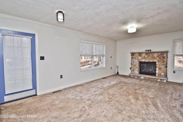 unfurnished living room featuring visible vents, a textured ceiling, carpet floors, a fireplace, and crown molding