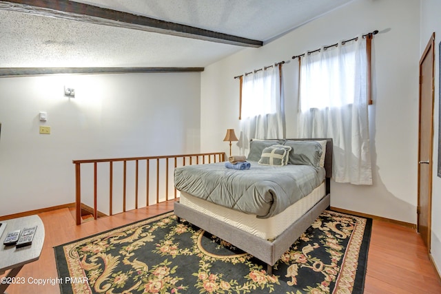 244 High Pass Way, Tannersville, PA 18372 - bedroom featuring a textured ceiling, baseboards, beam ceiling, and wood finished floors