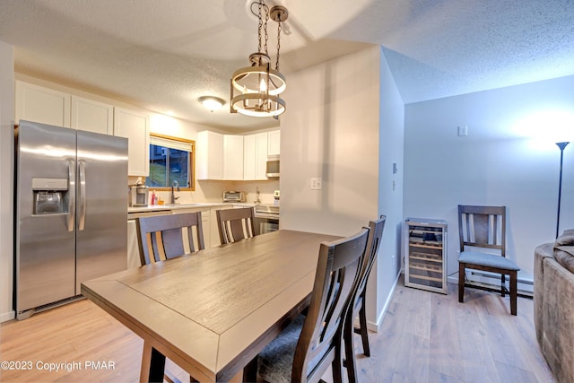 244 High Pass Way, Tannersville, PA 18372 - dining room featuring light wood-type flooring, beverage cooler, baseboards, and a textured ceiling