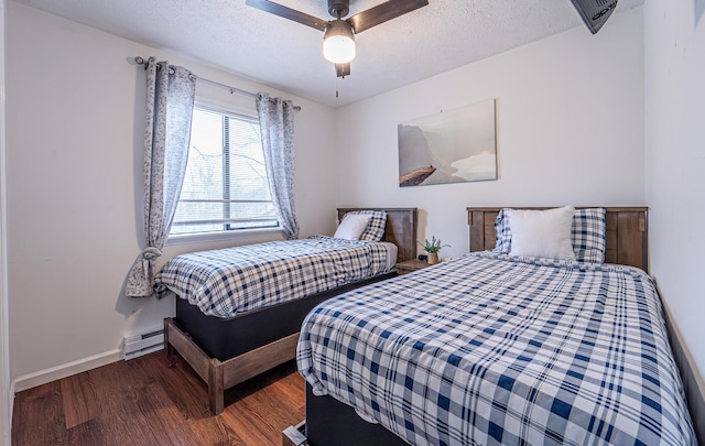 bedroom with a baseboard heating unit, a textured ceiling, baseboards, and wood finished floors