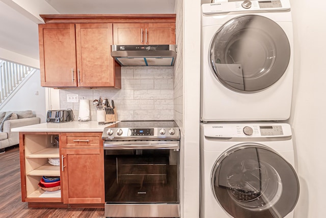 washroom featuring laundry area, stacked washing maching and dryer, and wood finished floors