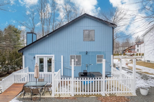 back of house featuring a deck, fence, and a chimney