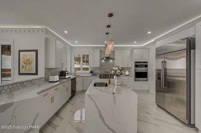 kitchen featuring marble finish floor, tasteful backsplash, appliances with stainless steel finishes, a sink, and wall chimney range hood