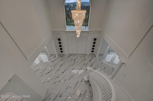 entryway with marble finish floor and an inviting chandelier