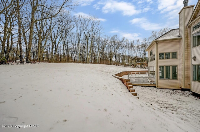 yard covered in snow with a deck