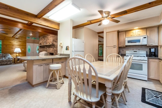 2173 Tuscarora Dr, Pocono Lake, PA 18347 - kitchen featuring white appliances, a peninsula, light tile patterned floors, open floor plan, and wooden walls