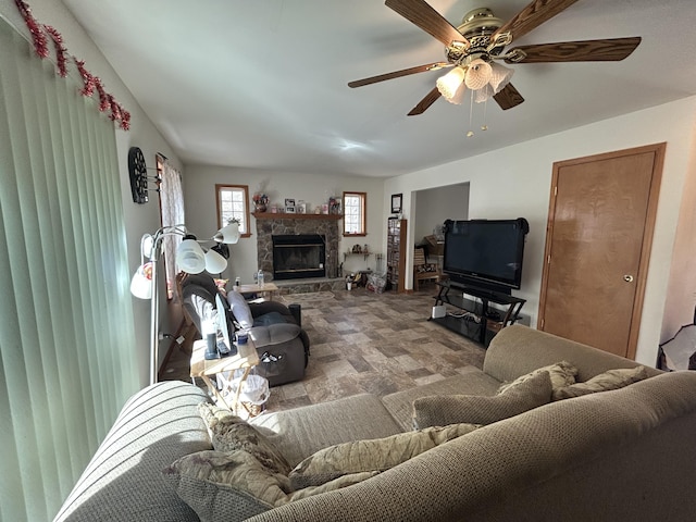 living room featuring ceiling fan and a fireplace