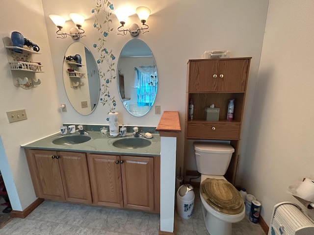 full bath with double vanity, a sink, and toilet