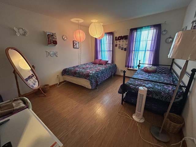 bedroom featuring baseboards and wood finished floors