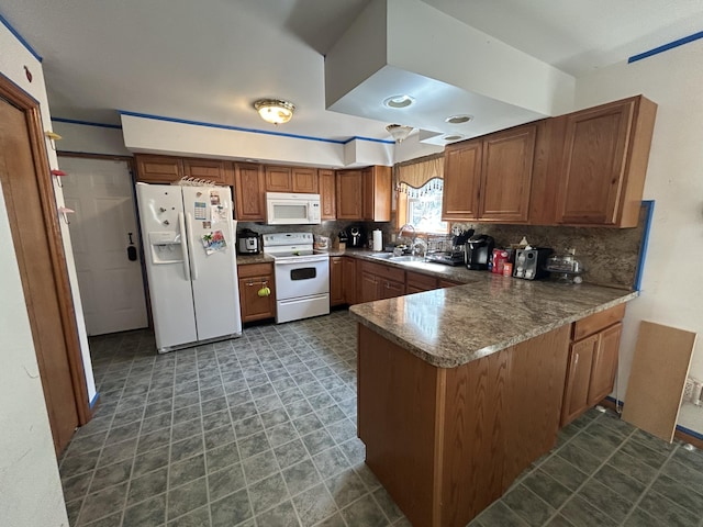 kitchen featuring decorative backsplash, a peninsula, white appliances, brown cabinets, and a sink