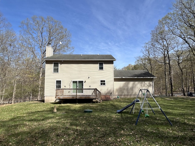 back of house featuring a yard, a wooden deck, and a chimney
