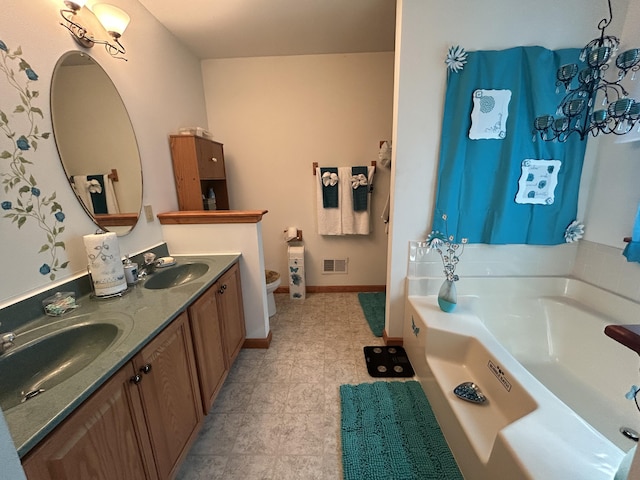full bath with double vanity, a sink, a bath, and toilet